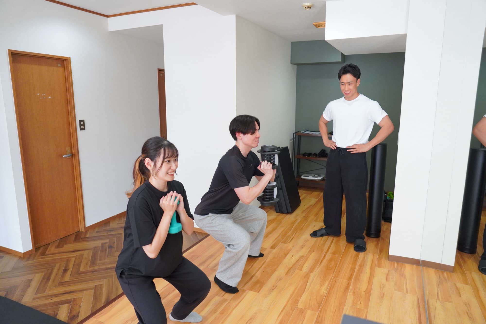 スクワットフォームを指導するトレーナー